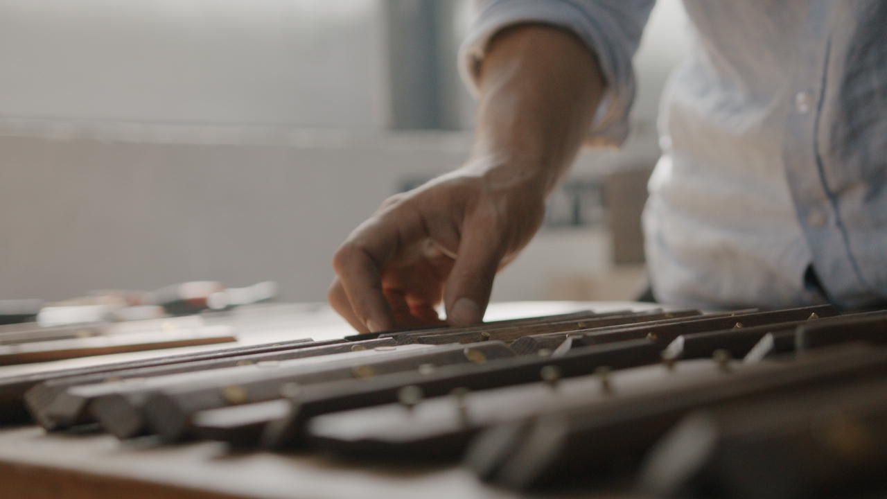 A hand examining the handles that are in the process of being finalised before being put onto Donkey Long Tongs.